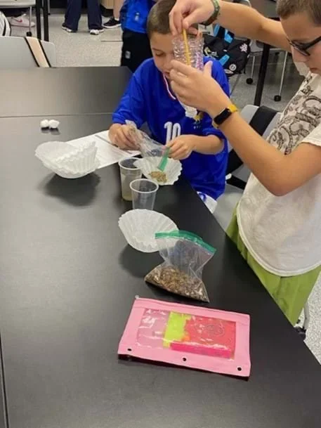 A photo showing students building water filtration systems.