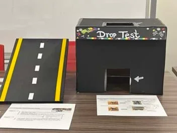 A photo of a quality test site, including a ramp, decorative box with a hole in the top that acts as a drop site, and building guidelines.