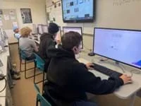 A photo of three students working at their lab computers.
