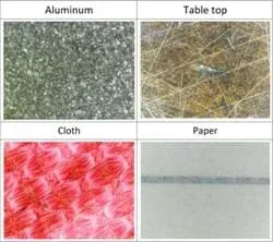 Aluminum, wooden tabletop, cloth and paper under the microscope. All surfaces exhibit roughness.