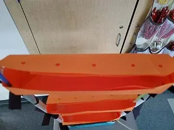 A student prototype of a hydroponics system hangs in a classroom. This design is a mock-up using paper materials.
