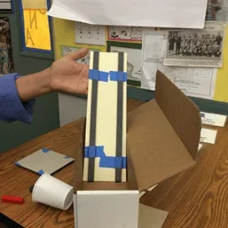 A photo showing an example maglev testing track, with two flexible magnet strips taped parallel to each other on a piece of tag board.