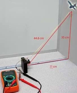 Photo shows a multimeter, airplane cutout, and Sharp GP2Y0A02YK0F sensor aimed at a wall. While the distance to the wall is unknown, the vertical distance along the wall to a clipart airplane is shown as 35 cm and the diagonal (slant range) distance from the clipart airplane to the sensor is shown as 44.8 cm.