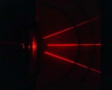 A photograph shows a red laser beam being diffracted into three beams as it passes through a diffraction grating.