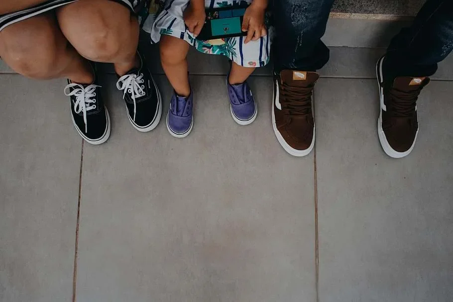 A photograph shows the shoes of two adults and one child.