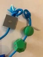 A photo of a blue cord with amino acid models on it and loops on both ends of the strand of amino acids.