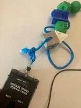 A photo of a blue cord with amino acid models on it and a Vernier force probe connected to one end of the strand.